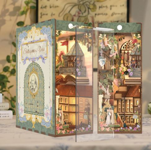 The Shakespears' Verse Large Book Nook by Blue Dog Posters features a vintage fairytale theme with whimsical buildings, flowers, and tiny characters in detailed pastel illustrations within an ornate frame.