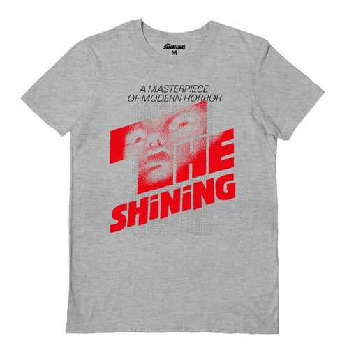 The Blue Dog Posters' The Shining Logo Grey T-Shirt XL features a design inspired by the movie "The Shining." It showcases a pixelated image of a man's face at the top, with the text "A Masterpiece of Modern Horror" above it and "The Shining" printed in large red letters below.