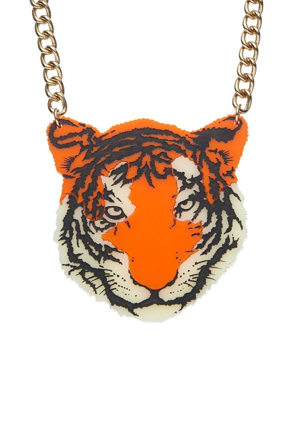 The Blue Dog Posters Tiger Necklace showcases a fierce tiger's face pendant, vividly illustrated with bold black lines and striking orange highlights. Hung on a chunky gold chain, this necklace is distinctive with the tiger’s prominent eyes and intricate facial details, all crafted from recycled acrylic.