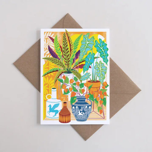 The Vessels Greeting Card by Printer Johnson from Blue Dog Posters features a colorful illustration of potted plants and vases on a vibrant yellow background, placed atop a recycled manilla envelope.