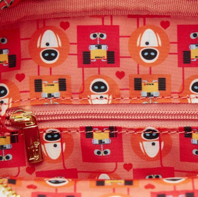 Close-up of the inner lining of the Blue Dog Posters Wall-E Date Night Crossbuddy Backpack, featuring a colorful, playful pattern with cartoon robots and hearts on a red background. The zipper is partially visible with a gold zipper pull, highlighting this Disney-Pixar merchandise's delightful attention to detail.