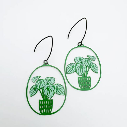 The Watermelon Peperomia plant Denz Earrings by Blue Dog Posters feature two earrings with green metal frames, depicting potted plants with striped leaves. They boast an intricately hand-drawn style and have thin black hooks against a plain white background.