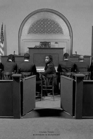 A black woman in a courtroom turns to look at the camera while others face forward; this formal scene with an American flag and judge's bench appears on the MUS 211 "Young Thug" poster.