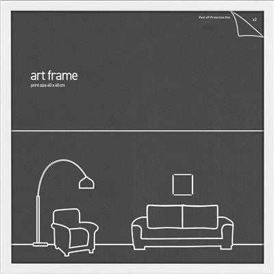 A Blue Dog Posters Classic Frame 40x40cm White features a simple illustration of a living room with a floor lamp, an armchair, a sofa, and small frames on the wall. The artwork is outlined in white on a dark gray background.