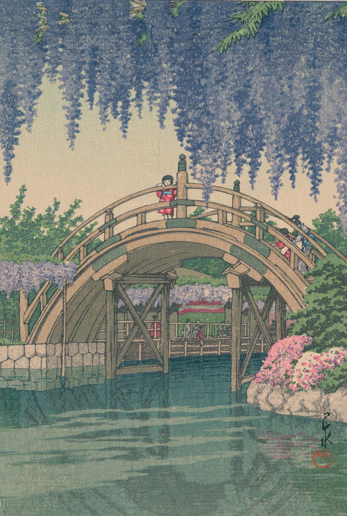 The "Wisteria at Kameido KAWASE HASUI" by Blue Dog Posters, now available as a high-quality A3 poster on 250gsm satin paper, depicts a curved wooden bridge over a serene pond surrounded by blooming wisteria and lush green foliage. Three people, including a child in red, stand on the bridge, enjoying the tranquil garden scenery.