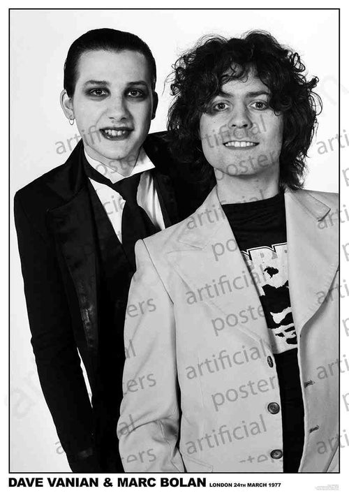 Two individuals, one with dark makeup and slicked-back hair wearing a suit, and the other with curly hair in a light-colored jacket, stand close together and smile for a black-and-white photograph. Text at the bottom reads, "Dave Vanian & Marc Bolan London 24th March 1977." Perfect for any rock poster collection. Presented by MUS 265's "The Damned and T REX Colour: Rock.