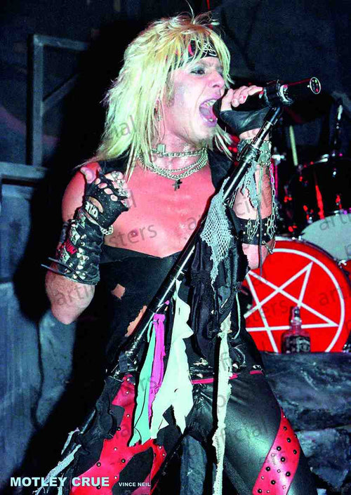 Vince Neil from Motley Crue is passionately singing into a microphone on stage. He has long, blond hair and is wearing a distressed black top, red pants, and various accessories including gloves and a choker. A drum set with a pentagram symbol is visible in the background—perfect for your Rock Poster Music Collection. This scene is beautifully captured on premium 150gsm gloss paper by MUS 124.