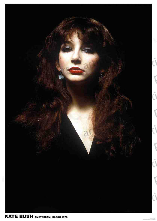 A woman with long, dark hair and bangs is pictured against a black background. She is wearing dark clothing and statement earrings, and her makeup features bold red lipstick. Text at the bottom reads "KATE BUSH AMSTERDAM, MARCH 1978." This striking music poster, "Kate Bush - Amsterdam 1978" by MUS 056, is printed on premium gloss paper for a stunning finish.
