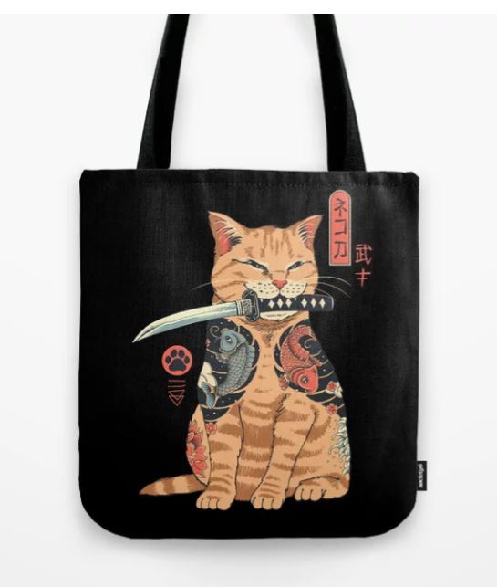 A Tote Bag 40x40cm Catana from Blue Dog Posters' Giftware Collection features an illustration of a ginger cat with a fish and dragon tattoo design. The cat holds a katana in its mouth and has Japanese characters on its right side. This sublimation printed design shows the cat sitting with a composed expression.