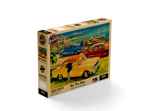 A 1000-piece jigsaw puzzle box titled "Holden - By the Bay 1000pc puzzle" from Blue Dog Posters. Officially licensed and part of their Giftware Collection, the box features a vibrant illustration of a vintage car scene by a coastal bay, showcasing several colorful classic cars and a person leaning on a yellow car.