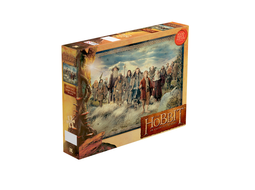 Box of "The Hobbit - Unexpected Journey 1000pc Puzzle" by Blue Dog Posters, featuring a picture of characters from the movie. The background shows a scenic, fantasy landscape with mountains and sky. Part of the Giftware Collection, the box highlights that it is an officially licensed 1000-piece puzzle.