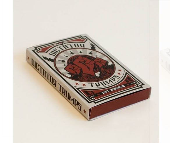 A rectangular box with the words "Gift Republic - Dictator Trumps" prominently displayed. The design features a clenched fist in the center, surrounded by stars and rays. Made from quality materials, the box has a red, black, and white color scheme with additional text "cart before the horse." Perfect for portable games or cool gifts by Blue Dog Posters.