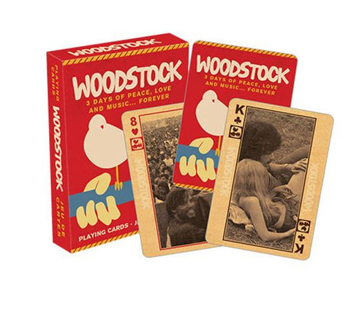 A set of Woodstock-themed playing cards is displayed. The red box shows a white bird sitting on a guitar, with "Woodstock" printed above and the words "3 Days of Peace, Love and Music... Forever" below. Two cards are shown, featuring black-and-white images from the event—cool gifts for your game night crew. These are the Woodstock Playing Cards by Blue Dog Posters.