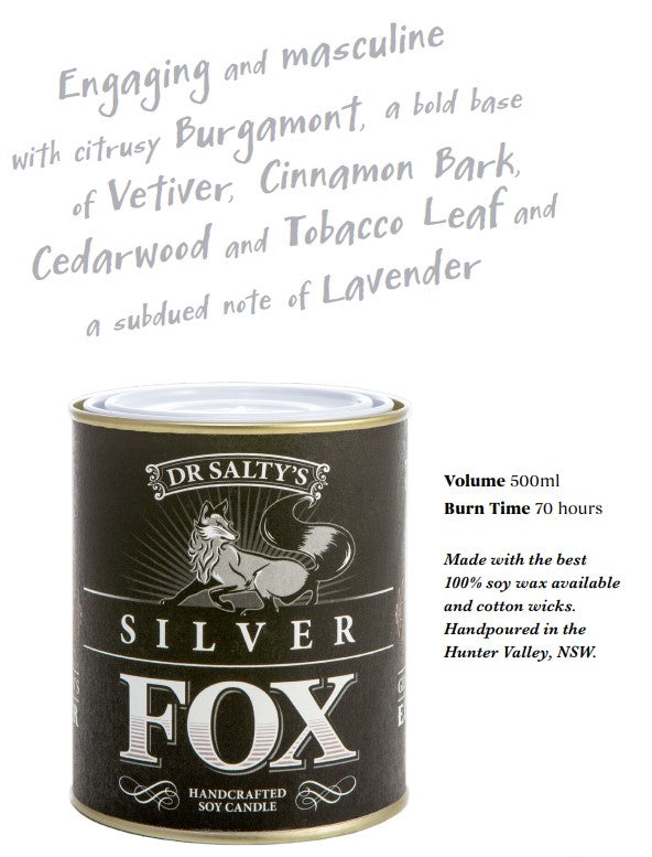 A product image of "Dr Salty Silver Fox Soy Wax Candle" by Blue Dog Posters. The label describes its masculine scent profile with notes of bergamot, vetiver, cinnamon bark, cedarwood, tobacco leaf, and lavender. This vintage-inspired candle is 500 ml with a burn time of 70 hours and crafted in NSW.