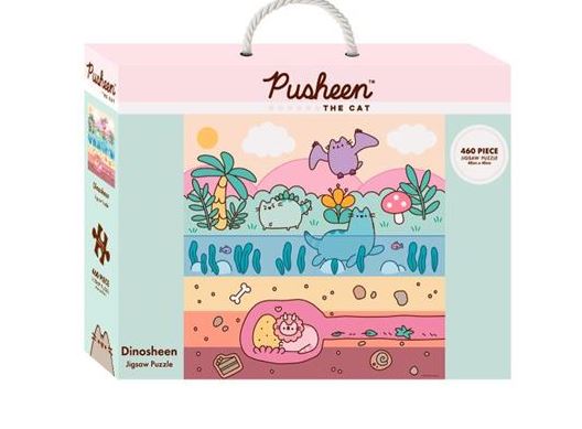 A pastel-colored puzzle box with a white handle features a cartoon dinosaur-themed scene including a cat named Pusheen. As part of the Officially Licensed Giftware Collection, the box displays "Pusheen Dinosheen - 460pc Puzzle" and "Blue Dog Posters." It contains 460 pieces, promising hours of fun.