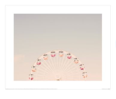 A pastel-colored photograph of a Ferris wheel against a clear sky. Ferris Wheel by Caroline Mint, featured in our Decor Series Collection from Blue Dog Posters, showcases a variety of colorful gondolas in shades of pink, red, and yellow, appearing to rise just over the horizon. This premium quality photographic art print is minimalistic and serene.