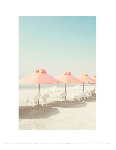A serene beach scene with a clear blue sky, featuring several pink umbrellas casting shade over white reclining lounge chairs on the sandy shore. This beautiful photographic art print, "Beach" by Caroline Mint from Blue Dog Posters, exudes a minimalistic and tranquil vibe as part of our Small Decor Series Art Prints.