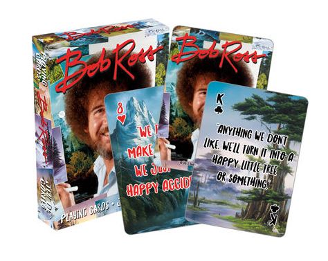 The Cool Gifts Collection features a set of Bob Ross Playing Cards by Blue Dog Posters. The packaging showcases Bob Ross with his iconic hairstyle and cheerful demeanor. Highlighted are two cards: the 8 of hearts adorned with "We don't make mistakes, just happy accidents," and the King of spades featuring "We'll turn it into a happy little tree or something.