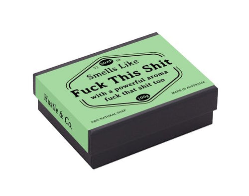A rectangular soap box with a green label reads: "Smells Like 'Fuck This Shit' with a powerful aroma 'fuck that shit too.'" Infused with natural extracts, the label also includes "S2, D10, 100g, MADE IN AUSTRALIA, 100% NATURAL SOAP." The side of the box reads "Hustle & Co.," perfect for sensitive skin. The product name is Hustle and Co Soap - Fuck This Shit and it's by Blue Dog Posters.
