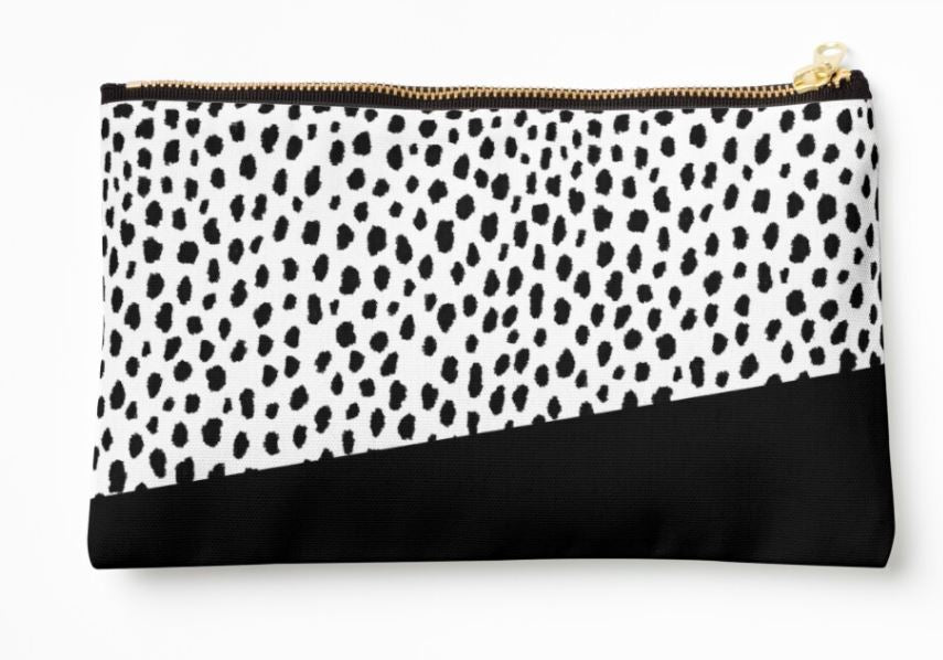 The Dalmation Spots Zipper Pouch Lge from Blue Dog Posters is a rectangular, artist-designed large zipper pouch with a white background featuring black Dalmatian spots on the top portion and a solid black section on the bottom. Crafted from durable polyester canvas, it is accentuated by a gold-colored zipper.
