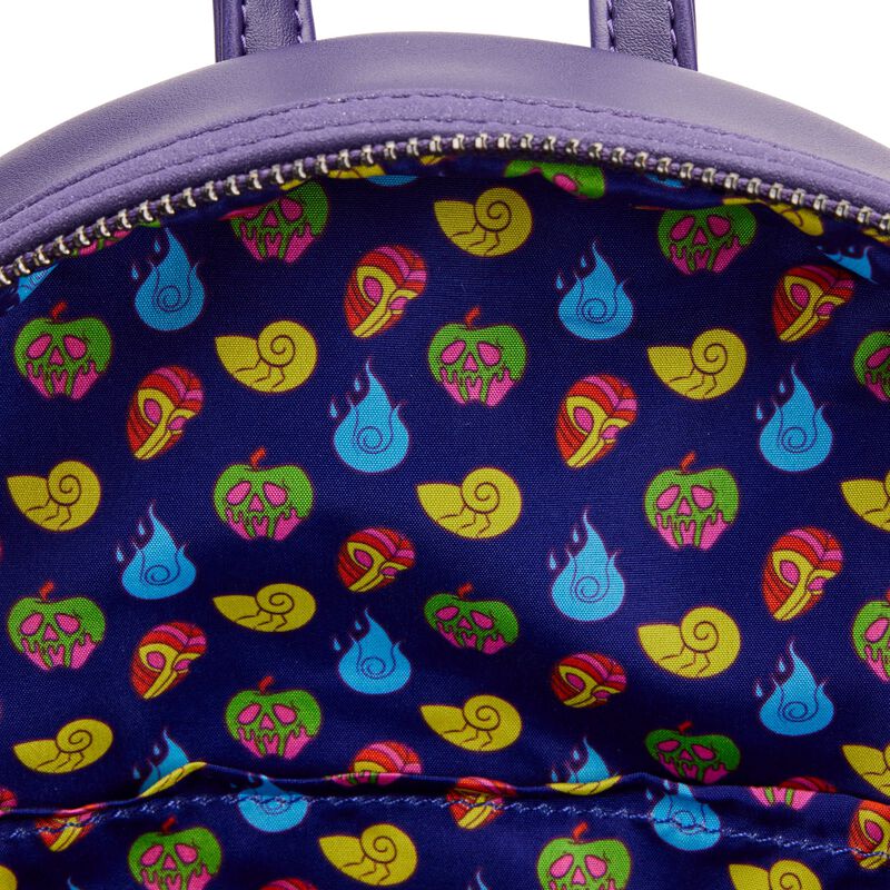 The image shows the inside lining of a Disney Villains Glow Mini Backpack by Blue Dog Posters. The lining features a colorful pattern of icons, including poison apples with skull faces, snail shells, green leaves, and blue flames, all set against a dark blue background that glows in the dark.
