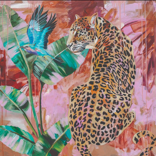 The vibrant art print titled "Distant longing" by Heylie Morris, from MEZ 513, features a leopard sitting calmly among tropical greenery with large leaves. A small blue hummingbird hovers nearby. The background is a mix of warm and cool hues, creating a dynamic, abstract effect that showcases the premium quality of her work.