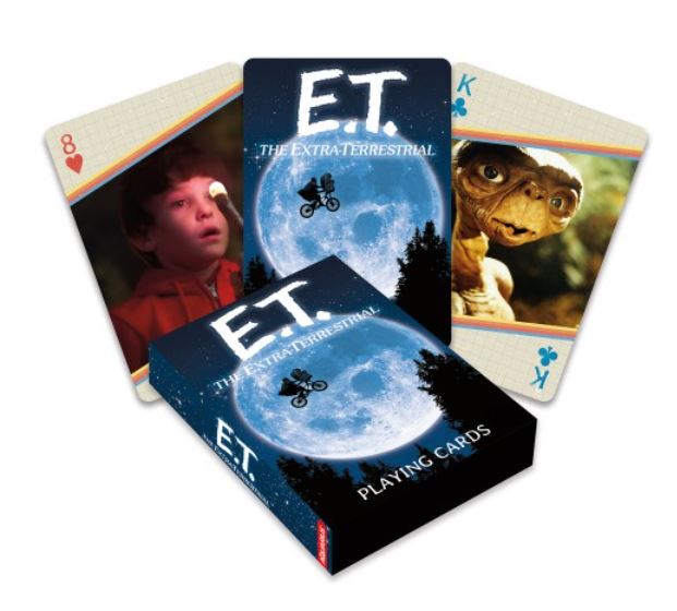 A pack of E.T. Playing Cards from Blue Dog Posters is shown, boasting a unique design. The box features an image of E.T. and Elliott flying a bicycle across the moon. Two visible cards depict scenes from the movie, including one with E.T. and a boy, and an 8 of hearts card featuring Elliott.