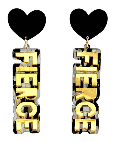 The Haus of Dizzy Fierce Gold Tiger Earrings from Blue Dog Posters are a pair of dangle earrings with black heart-shaped studs at the top. These striking earrings feature the word "FIERCE" in bold gold-colored letters, surrounded by a geometric black and white pattern. The word "FIERCE" hangs vertically from the heart-shaped studs.