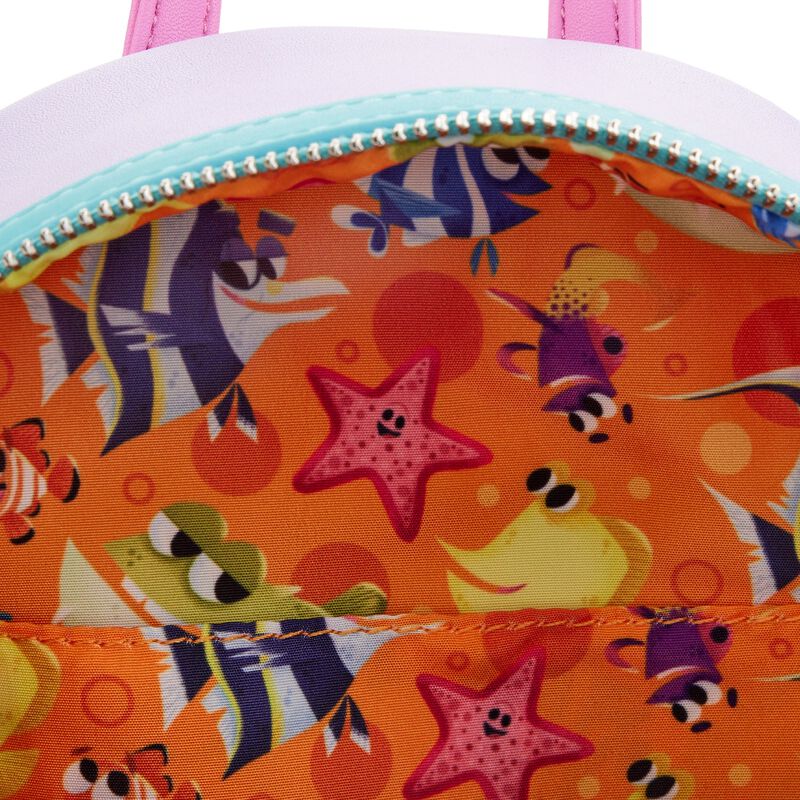 A close-up of the Finding Nemo Darla Mini Backpack by Blue Dog Posters reveals a vibrant interior featuring an ocean-themed pattern inspired by Finding Nemo. The design showcases cartoon fish, a starfish, and various sea creatures set against an orange background. The slightly open zipper offers a peek into this whimsical Disney character fabric.