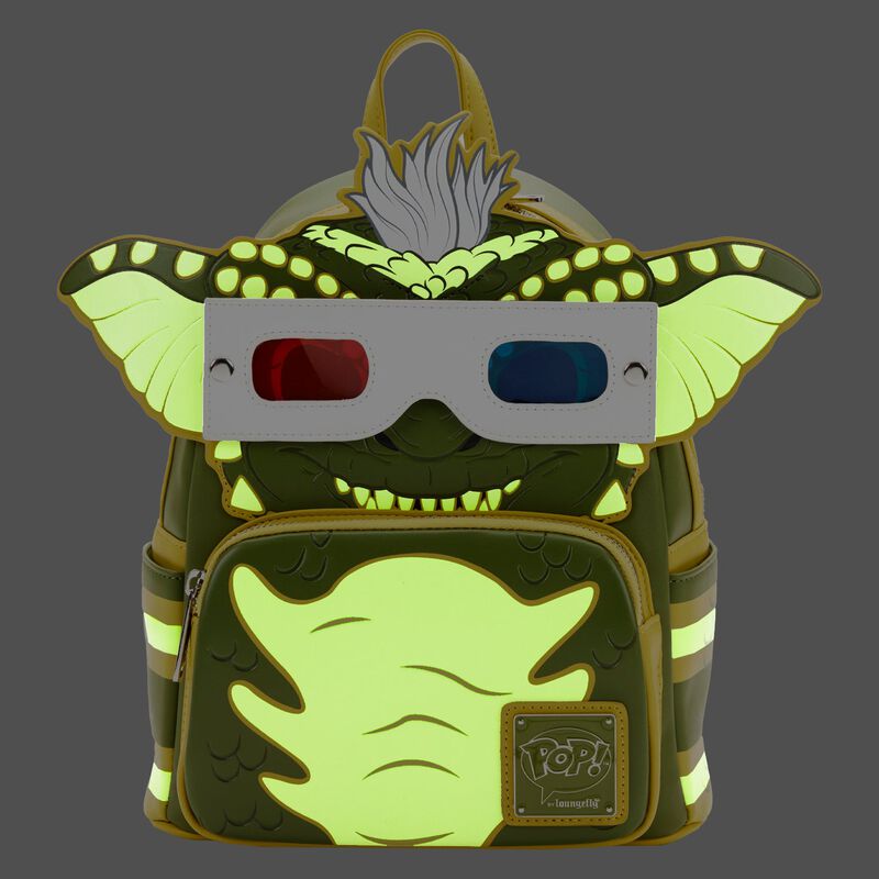 The Gremlins Stripe Mini Backpack by Blue Dog Posters is a whimsical accessory designed to resemble a playful green monster with large ears and a furry tuft of hair. The monster wears 3D glasses, adding a fun touch to the design. With neon green glow-in-the-dark straps and details, this backpack also features a small front pocket adorned with a tag reading "Pop Loungefly.