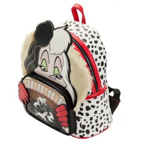 The Blue Dog Posters 101 Dalmatians Cruella Mini Backpack features a striking black and white spotted design mimicking a Dalmatian pattern. The front highlights a cartoon depiction of Cruella De Vil with her signature black and white hair, green eyeshadow, and red gloves, peering over a small pocket that showcases an adorable scene of Dalmatian puppies.