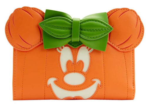Introducing the Disney Minnie Pumpkin Face Flap Purse by Blue Dog Posters: an orange clutch purse crafted from vegan leather, designed to resemble a cartoon character's face. This Halloween accessory features a prominent green bow at the top, along with a cheerful smiling expression complete with white eyes and mouth accents. Stitched details mimic the character's ears, making it a charming addition to your festive wardrobe.
