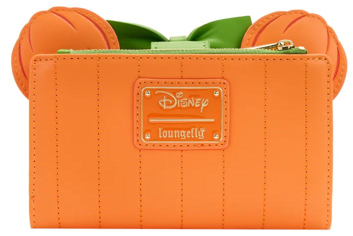 The Disney Minnie Pumpkin Face Flap Purse from Blue Dog Posters, crafted from vegan leather, showcases a pumpkin design with stitched details. Perfect as a Halloween accessory, it features a zipper closure with green accents and a bow, pumpkin-shaped ears at the top corners, and a gold Disney Loungefly logo centered.