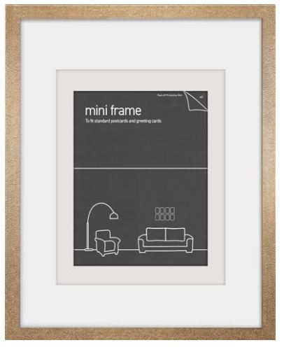 A Deluxe Postcard Frame 10x14.5cm - Gold by Blue Dog Posters with a beige border and white matting. The inner section displays a placeholder image of a minimalist living room with a lamp, chair, and sofa, above which "mini frame" text is printed. The frame is designed to fit standard postcards and greeting cards.