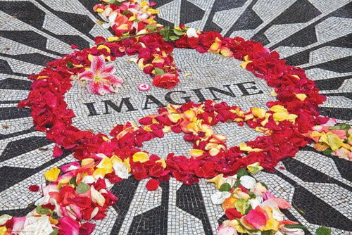 A mosaic with the word "IMAGINE" at its center, surrounded by a peace sign made from red, yellow, and pink flower petals. The radial pattern of black and white tiles is printed on premium 150gsm gloss paper, with additional scattered petals enhancing the vibrant, thoughtful display. This beautiful piece is called "Imagine" by MUS 037.