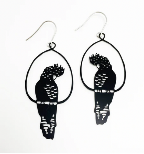 The Denz Cockatoo Black Earrings by Blue Dog Posters are a pair of handcrafted earrings from Noosa, shaped like birds perched in oval frames. Featuring intricate cutouts that highlight the details of the feathers and body, these super lightweight statement pieces are crafted from recycled stainless steel and come with simple fishhook wire closures.