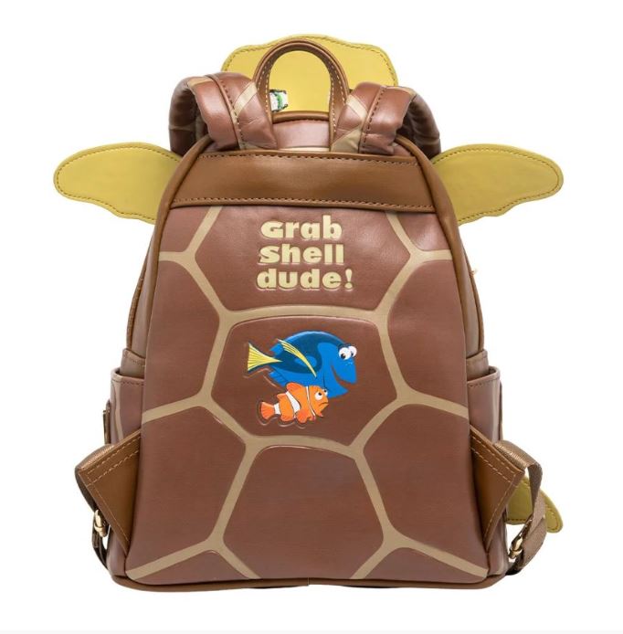 The Finding Nemo Crush Mini Backpack by Blue Dog Posters features a brown design resembling a turtle shell with the phrase "grab shell dude!" written on it. Below the text are illustrations of two animated fish from Finding Nemo, one blue with yellow fins and the other orange with white stripes. This faux leather mini backpack includes green straps and side pockets.