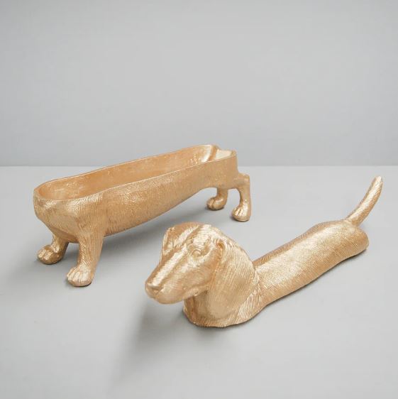 Two Dachshund DOG Bowl gold trays by Blue Dog Posters—one open with the full dog figure, one closed with raised head and tail—make striking home décor accents against a plain gray background.