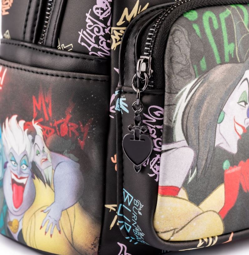 Close-up of the Disney Villains Club Mini Backpack by Blue Dog Posters, showcasing colorful illustrations of iconic Disney villains such as Ursula and Cruella de Vil. This faux leather mini backpack features multiple zippered compartments, with a black heart-shaped zipper pull on one pocket. The background displays various villain-themed graffiti.