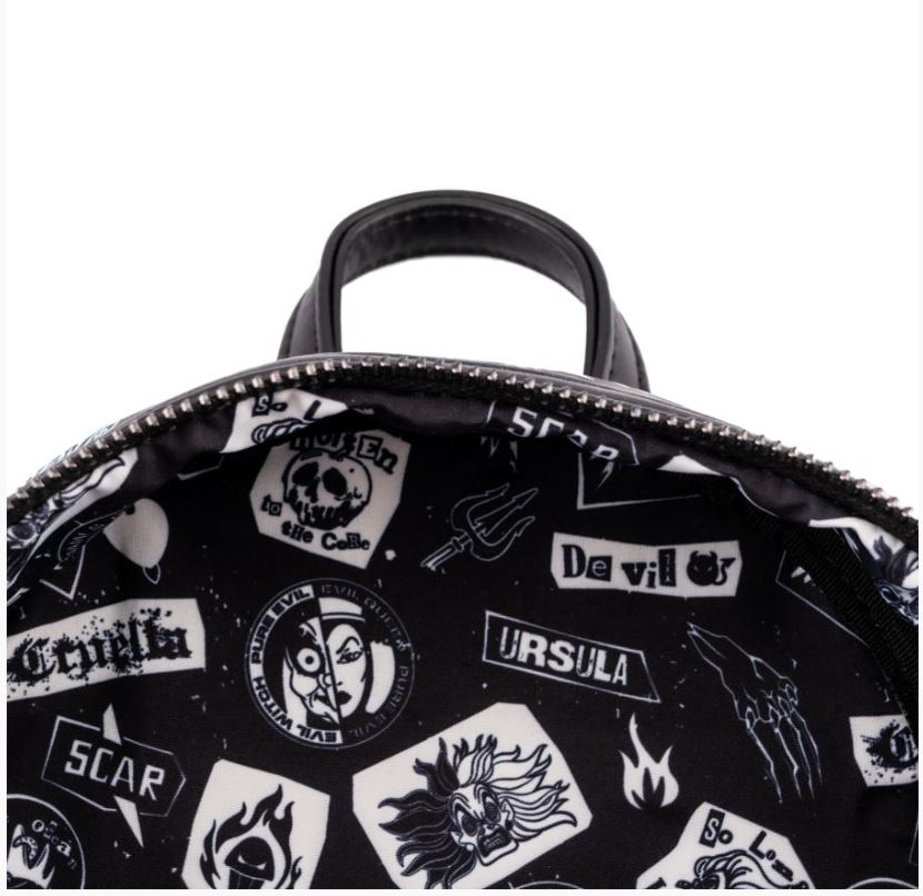 Close-up image of the interior of the Blue Dog Posters Disney Villains Club Mini Backpack displaying a black and white printed lining. The lining features various graphics and text related to Disney Villains, such as "Ursula," "Cruella," and "Scar," with symbols like flames and skulls prominently displayed.