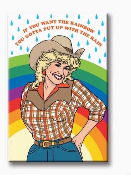 A smiling woman in a cowboy hat and plaid shirt stands with one hand on her hip, framed by a rainbow and raindrops. The text above her reads, "If you want the rainbow, you gotta put up with the rain." Fridge magnets pinch important notes below, reminding house guests of these wise words. This scene is captured perfectly in the Dolly Want the Rainbow Magnet by Blue Dog Posters.