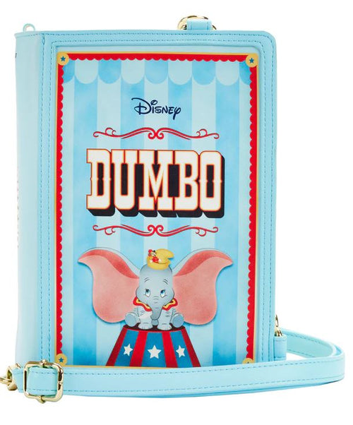 A pastel blue Dumbo 1941 Book Convertible Crossbody by Blue Dog Posters features an illustration of Disney's Dumbo, the flying elephant, against a striped circus backdrop. Dumbo sits on a circus platform with his large pink ears open wide. The word "Dumbo" is prominently displayed above him in bold red letters.