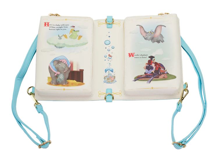 A cream-colored Dumbo 1941 Book Convertible Crossbody by Blue Dog Posters, crafted from vegan leather with blue straps and gold clasps, features charming cartoon illustrations of an elephant on the left page and a flying elephant on the right. When closed, this Disney-inspired accessory transforms into a delightful purse.