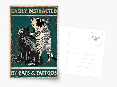 The "Easily Distracted by Cats & Tattoos Postcard" by Blue Dog Posters showcases a vintage-style design featuring two cats: one white cat tattooing a design on a black cat. Both felines sport intricate tattoo patterns, set against a distressed texture with vibrant pops of color. The reverse side has space for your message, as it's part of the Cards Collection.