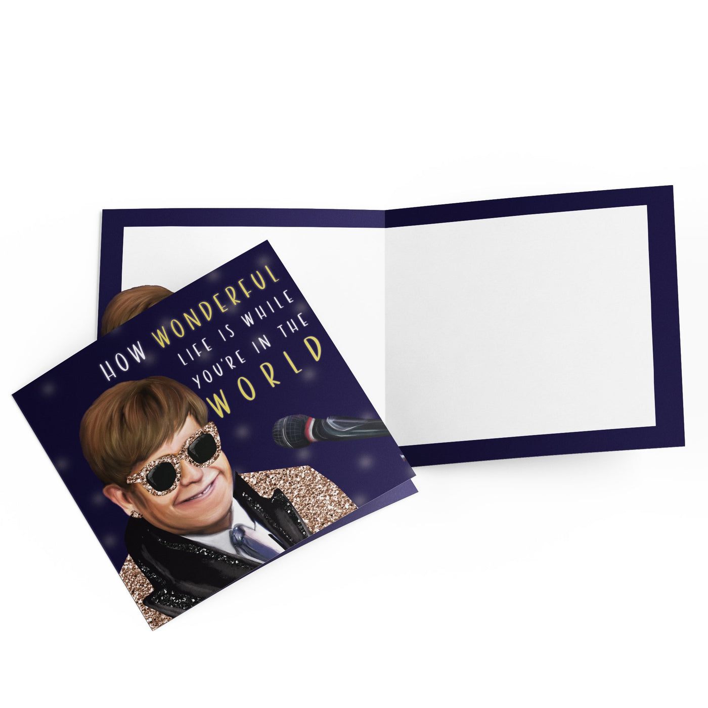 A delightful addition to our Greeting Card Giftware Collection, the Blue Dog Posters Greeting Card - Wonderful Elton features a portrait of a person wearing sunglasses and a glittery jacket, smiling at a microphone. The front reads, "How wonderful life is while you're in the world." Inside is blank with a dark border, crafted from quality materials.