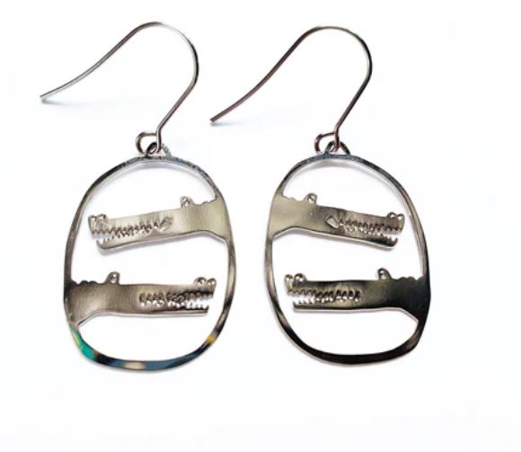 The Denz Mini Earrings Crocs Silver by Blue Dog Posters are a stunning pair of silver dangle earrings showcasing an oval shape with delicate cut-out crocodile designs etched within the ovals. These unique and captivating earrings, made in Australia, feature surgical steel hooks for pierced ears.