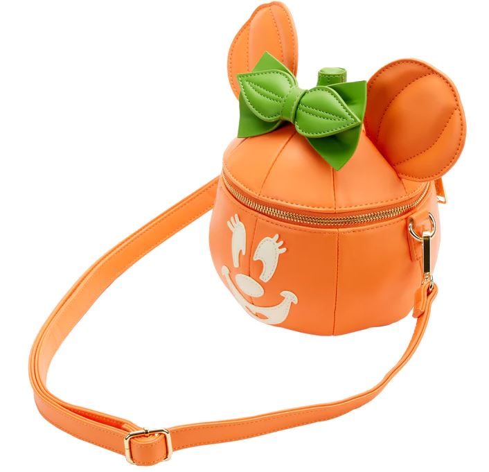 The Blue Dog Posters Disney Minnie Pumpkin Face Crossbody Bag is an orange crossbody shaped like a pumpkin with round mouse ears, featuring a green bow on top. It has a cute face design and is perfect as a Halloween accessory. This adorable bag comes with a zip closure, matching strap, and hardware.