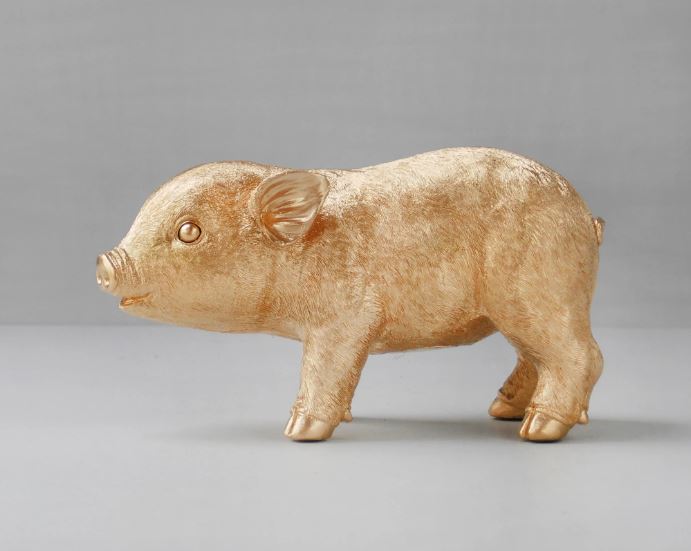 A Blue Dog Posters' Pig Money Box - Gold, featuring a gold-painted piggy bank standing on all fours against a plain gray background. The sculpture boasts detailed features such as ears, eyes, and snout, with a slightly textured surface that lends it a realistic appearance. Coin access is cleverly hidden to maintain its elegance.