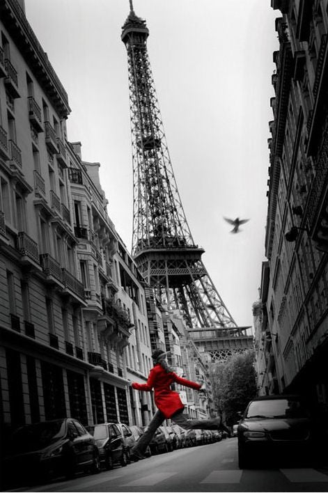 A black and white cityscape poster features the Eiffel Tower in the background. The only color in the image is a person wearing a bright red coat, jumping joyfully in the middle of a street lined with buildings. A bird is also seen flying above, adding to *Red Coat in Paris* from our NAT 058 Scenic Collection.