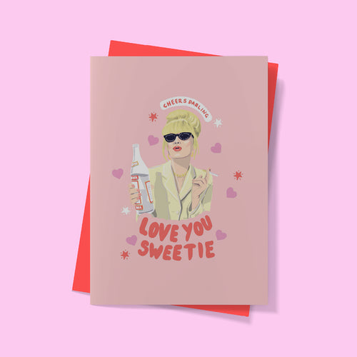 An Amy Blue Greeting Card Love you Sweetie from our Blue Dog Posters Giftware Collection features an illustrated person wearing sunglasses and holding a bottle, with "CHEERS DARLING" in a speech bubble above and "LOVE YOU SWEETIE" in bold red letters below. It includes a matching envelope and is set against a pink background with heart decorations.